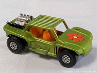 Metallic green 1971 Matchbox Lesney Baja Buggy die cast car with orange seats, flower decal on hood and visible rear engine detail