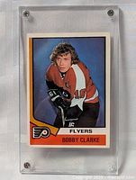 Front view of Bobby Clarke 1974-75 OPC hockey card in a hard plastic case.