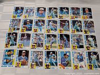 Single photo showing 36 individual baseball cards arranged in rows, all featuring Toronto Blue Jays players from the 1984 Topps set in well-preserved condition.