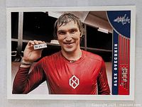 Front photo of the Alex Ovechkin hockey card showing him in red shirt holding a puck with Washington Capitals branding.