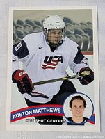 Front of 2015 Auston Matthews hockey card showing player in USA jersey with stick and inset headshot.
