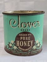 Front and side views of vintage Clover Brand honey tin showing branding and condition.