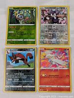 Four Pokemon cards arranged: Rowlet, Indeedee, Thievul, Reshiram. Shows holo foil effect on three cards.