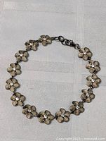 Loose view of the entire floral sterling silver bracelet showing linked flower elements with diamond centers.