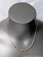 Front view of sterling silver necklace on display bust, showing overall design and bead placements along the chain.