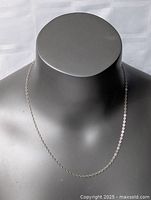 Sterling silver necklace displayed on a black mannequin bust showing the full chain length and linkage style.