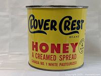 Front view of vintage yellow Clover Crest honey tin showing brand name, product description, and weight.
