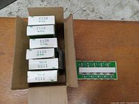 Open box showing multiple smaller boxes each marked 1156 containing 10 bulbs per box, plus an example cardboard holder with 10 bulbs visible.