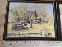 Photo of framed painting showing a rural scene with a vintage car and house, signed by Doug Fraser
