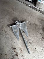 Photo of a 44 pound Danforth style boat anchor laying on concrete floor showing two flat flukes and central shank.