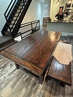 Tabletop and bench in room setting, shows dark stained plank top and bench placement