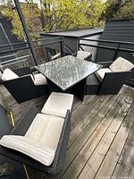 Assembled patio set on deck showing table, chairs, footstool, and cushions