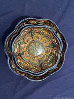 Top view of nested Talavera ceramic bowls showing detailed floral interior pattern in orange, green, and blue.