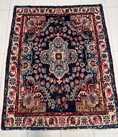 Full view of rug laid flat on tile floor showing overall pattern and condition