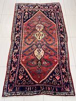 Full view of the rectangular handmade Persian Hamadan rug showing the multi medallion design on reddish field with navy blue borders and detailed floral and geometric motifs.