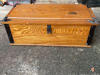 Front view of chest showing wood grain and metal reinforcements