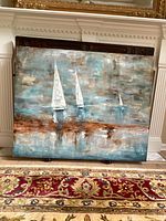 Full view of the sailboat painting leaning against fireplace