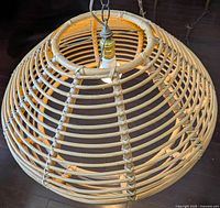 Close-up view of the rattan shade and bulb holder from above showing the woven rattan in natural finish with chain hanging.