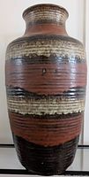 Front view of large striped ceramic floor vase showing color bands and texture