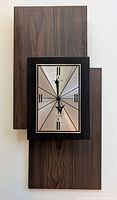 Full view of the mid century Bulova wall clock showing rectangular black frame and wood panel background.