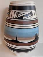 Clear frontal image of the Navajo hand painted pottery vase showing geometric patterns and desert landscape band.