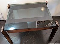 Front angled view of the rosewood side table with glass top showing overall condition and design.