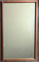 Full view of rectangular mirror with teak wood frame.