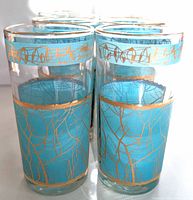 Front view angle of the eight tumblers showing the blue and gold pattern details on the glasses.