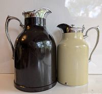 Photo of two vintage thermos carafes, one black and larger, one cream and smaller, showing overall condition and design.