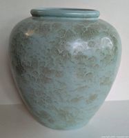 Front view of West German pottery vase showing light blue glaze with textured floral pattern.
