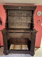 Full front view of sideboard showing carved crest, open shelves, drawer and lower storage shelf