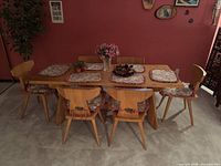 Full view of rectangular pine dining table with six matching chairs arranged around it