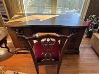 Frontal view of the carved oak desk and matching chair showing overall appearance