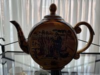 Full side view of Satsuma-style flask or teapot showing traditional Japanese figures in traditional dress and landscape.