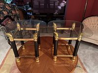 Front view of both glass and brass side tables showing full frames and tops