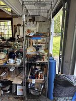 Full view of 6-foot tall metal shelving unit with multiple wire grid shelves, showing typical use wear and the shelving configuration.