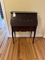 Front view of desk closed showing carved front panel and overall condition