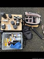 Overview of all items including Pentax camera with lenses, flash, film rolls, accessories, and camera bags on ground setup for inventory.