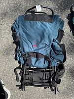 Front view of blue EMS hiking backpack showing multiple straps, black waist belt, and main compartment with EMS logo.