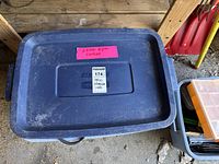 Closed blue plastic bin labeled for miscellaneous extension cords and power strip
