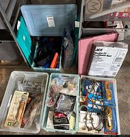 Multiple plastic bins and containers filled with assorted home hardware items and accessories shown from top view.
