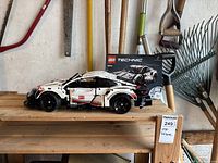 Side view of the assembled Lego Technic Porsche 911 RSR model on a wooden surface, with original box placed behind it.