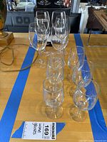 Eight stemmed wine glasses arranged on table showing different sizes, clear glass with long stems.