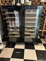 Front view of dual door wine fridge with digital controls and wine bottles inside on wooden shelving.