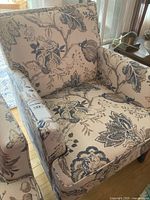 Front view of the cloth covered arm chair showing floral fabric and overall shape