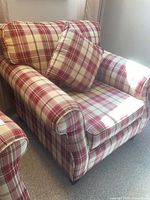 Front three-quarter view of plaid armchair with loose seat and back cushions and matching pillow