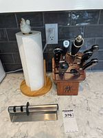 Knife block with six knives and paper towel holder on kitchen countertop
