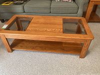 Full view of wooden coffee table with two glass inserts on the tabletop, showing overall shape and design.