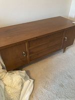 Full view of cedar chest showing smooth wood top, side doors, and central slatted panels.