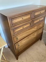 Angled view of the full wooden dresser showing five drawers and top surface.